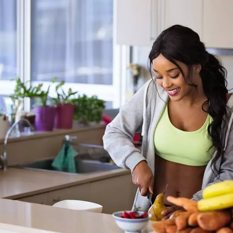Attractive African American young woman preparing vegetables and living a Healthy lifestyle